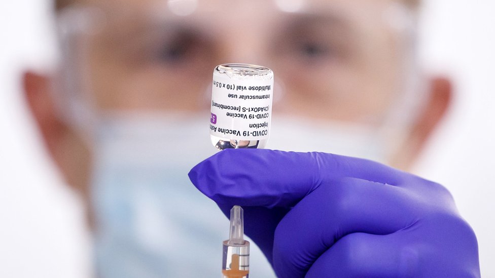 A man holding the Oxford vaccine